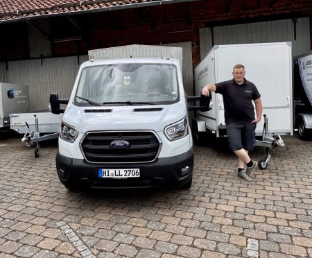 Ein Lieferdienstfahrzeug auf einem Hof mit einem freundlichen Fahrer